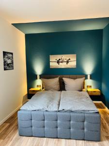 een slaapkamer met een groot bed met een blauwe muur bij Himmlische Weite 3 in Schweinfurt