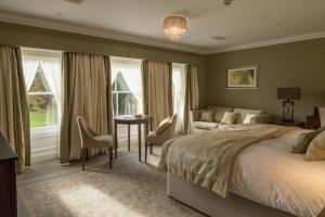 a bedroom with a bed and a couch and a table at Oakley Hall Hotel in Basingstoke