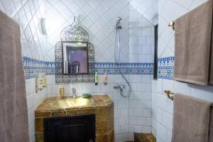 a bathroom with a sink and a mirror at Kasbah Dar Daif in Ouarzazate