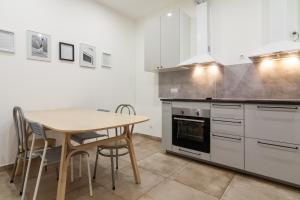 a kitchen with a wooden table and a table and chairs at BAZZE in Klaipėda