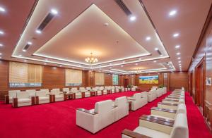 una sala de conferencias con sillas blancas y alfombra roja en Khách Sạn A1, en Lạng Sơn
