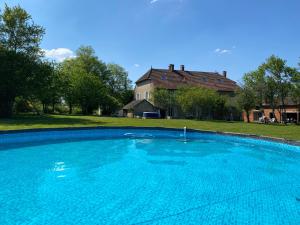a large blue swimming pool in front of a house at Le Meix 