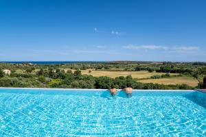 Dos personas de pie en una piscina con vistas en I Carusi Relais, en Noto 37 fotos más