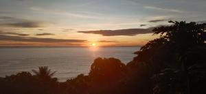una puesta de sol sobre el océano con el sol en el cielo en The view padang, Amazing view, food, drink, sleep, transport, 8 mins Mentawai fast ferry en Padang