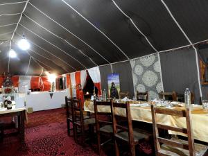Tienda de campaña con mesa y sillas en una habitación en Room in Guest room - Luxury Desert Camp - Merzouga, en Tisserdmine