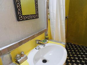 y baño con lavabo blanco y espejo. en Room in Guest room - Luxury Desert Camp - Merzouga, en Tisserdmine