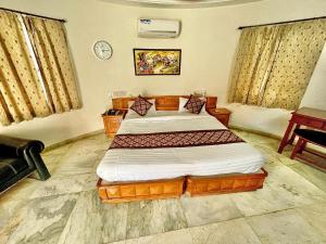 1 dormitorio con 1 cama y reloj en la pared en RESORT FARM VILLA, en Bhuj