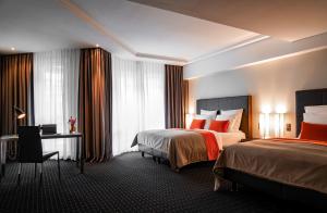 ein Hotelzimmer mit 2 Betten und einem Schreibtisch in der Unterkunft Boston Hotel HH in Hamburg