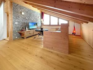 a living room with a desk and a stone wall at Chalet Etoile Polaire in Nendaz