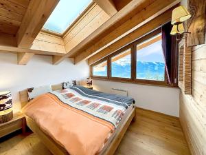 um quarto com uma cama num quarto com janelas em Chalet Etoile Polaire em Nendaz