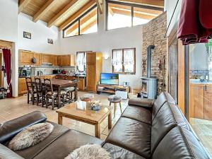 a living room with a leather couch and a table at Chalet Etoile Polaire in Nendaz