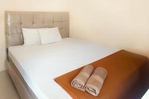 a white bed with two towels on a wooden tray at Fabel Homestay in Palembang