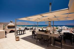 een patio met een tafel en stoelen en uitzicht op de oceaan bij Anastellar in Kissamos