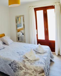 a bedroom with a bed with towels and a mirror at Tuent in Port de Pollensa
