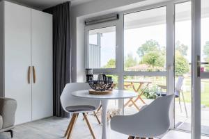 a dining room with a white table and chairs at Haus Seeblick Wohnung 04 in Wohlenberg