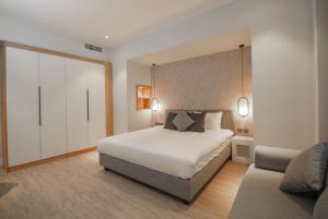 a bedroom with a large bed and a couch at Loft Hotel Apartment in Addis Ababa