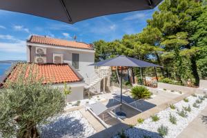 a house with a patio and an umbrella at Brela - room for two in Brela