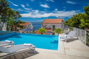 a swimming pool with two lounge chairs next to a house at Brela - room for two in Brela +11 photos