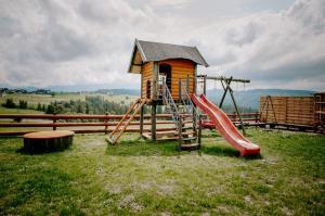 um pequeno parque infantil com escorrega e escorrega em LassChata - Domki w górach z balią em Zakopane