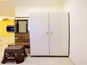 a large white cabinet in a room with a stool at IVY RESIDENCY in Coimbatore