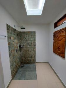 a bathroom with a shower with a brick wall at Santan Gili Cottages in Gili Trawangan