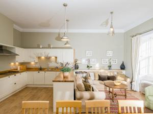 a kitchen and living room with a couch and a table at Lauderdale Apartment - UK30765 in Ardovie