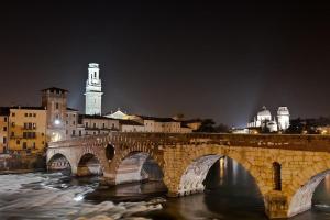 a bridge over a river in a city at night at Residenza Cantore in Verona