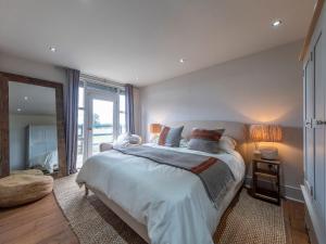 a bedroom with a large bed and a large window at Green Farm Barn in Wrenbury