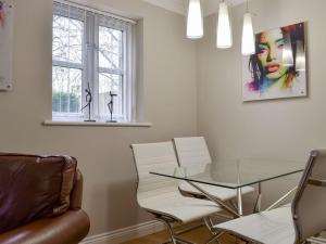 a dining room with a glass table and white chairs at Hollies Cottage 2 - Ukc4520 in Martock