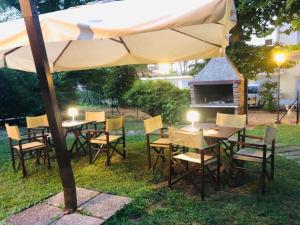 a table and chairs under an umbrella in the grass at Hotel President in Cervia