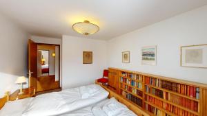 a bedroom with a bed and bookshelves at Mutaun in Silvaplana