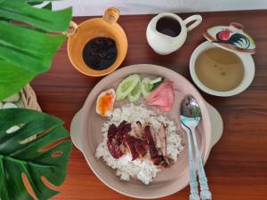 un plato de comida con arroz y fruta y una taza de café en The Greenergy - NO ELEVATOR en Hat Yai