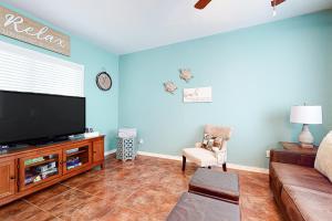 uma sala de estar com uma televisão de ecrã plano e um sofá em Lyla's Beach Getaway em Padre Island