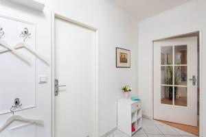 ヴェスターラントにあるFerienwohnung Odinの白いバスルーム(シャワー、ガラスドア付)