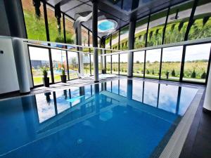 une grande piscine avec un grand groupe de fenêtres dans l'établissement Resort Westin House - 365PAM, à Kołobrzeg