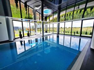 ein großer Swimmingpool mit einer großen Fenstergruppe in der Unterkunft 365PAM - Resort Westin House - BASEN, JACUZZI, SAUNA, SIŁOWNIA, PLAC ZABAW W CENIE in Kołobrzeg