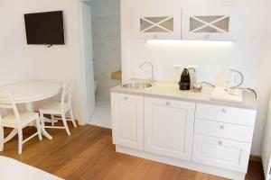 a white kitchen with a sink and a table at Residenza Cantore in Verona