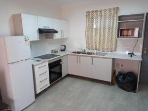 a kitchen with a white refrigerator and a sink at TOP VIEW LUXURY APARTMENT in Centurion