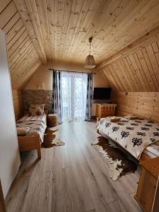 een slaapkamer met 2 bedden en een houten plafond bij Góralska Chatka z Balią 2 - ZAKOPANE in Zakopane