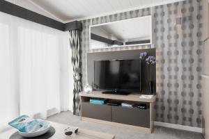a living room with a television on a entertainment center at Braddicks Holiday Centre in Westward Ho +53 photos