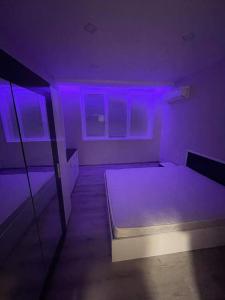 Cette chambre dispose d'un lit avec des lumières violettes. dans l'établissement Family flat for rent, à Montana