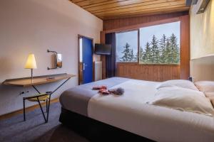 Кровать или кровати в номере Belambra Clubs Arc 1800 - Hôtel Du Golf
