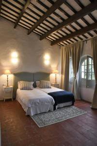 a bedroom with a large bed and two windows at Masia Can Pitu in Santa Cristina d'Aro