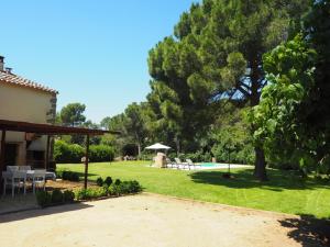 um quintal com piscina, cadeiras e árvores em Masia Can Pitu em Santa Cristina d'Aro