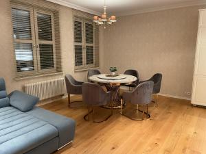 een woonkamer met een tafel en stoelen en een bank bij Apartament Faltom Gdynia Centrum in Gdynia