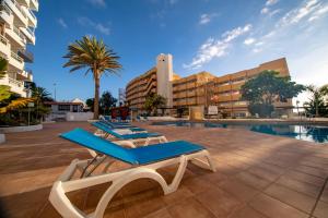 Una piscina con tumbonas y un edificio. en Ponderosa 615, Las Americas, one bedroom apartment with large terrace and ocean view, next to Siam Park, en Playa de las Américas