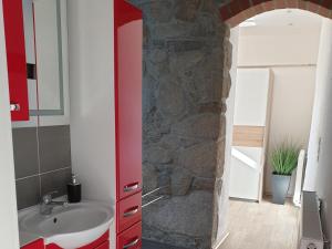 a bathroom with a sink and a stone wall at Ferienhaus Oberlausitz in Cunewalde