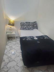 a bedroom with a black and white bed and a table at Comfy zone in Abu Dhabi