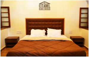 a bedroom with a large bed with two night stands at Citadel Resort in Panchgani