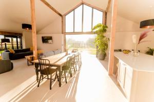 a dining room and living room with a table and chairs at Beautiful Barn Conversion Close To The Broads in Dilham